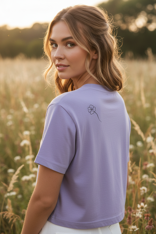Woman in three-quarter back view wearing lavender Clover Crop top with one-line clover on shoulder