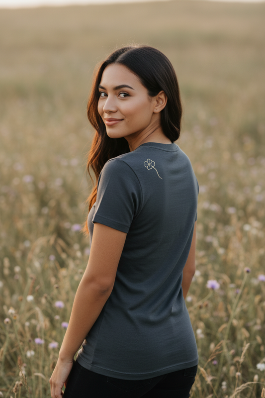 Person in three-quarter back view wearing dark grey Clover Slim tee with one-line clover on shoulder